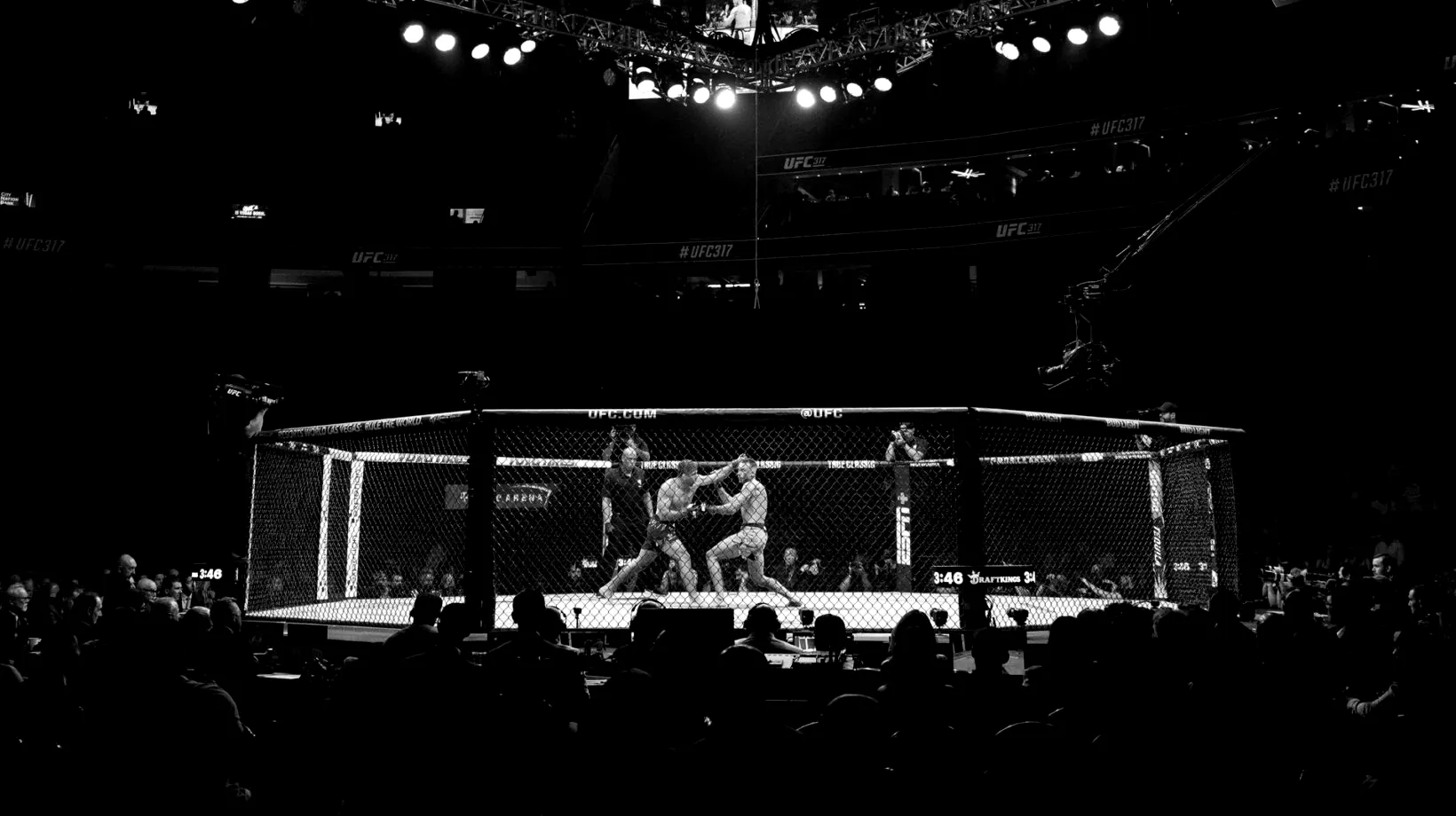 A combat sports athlete inside the cage under arena lights.